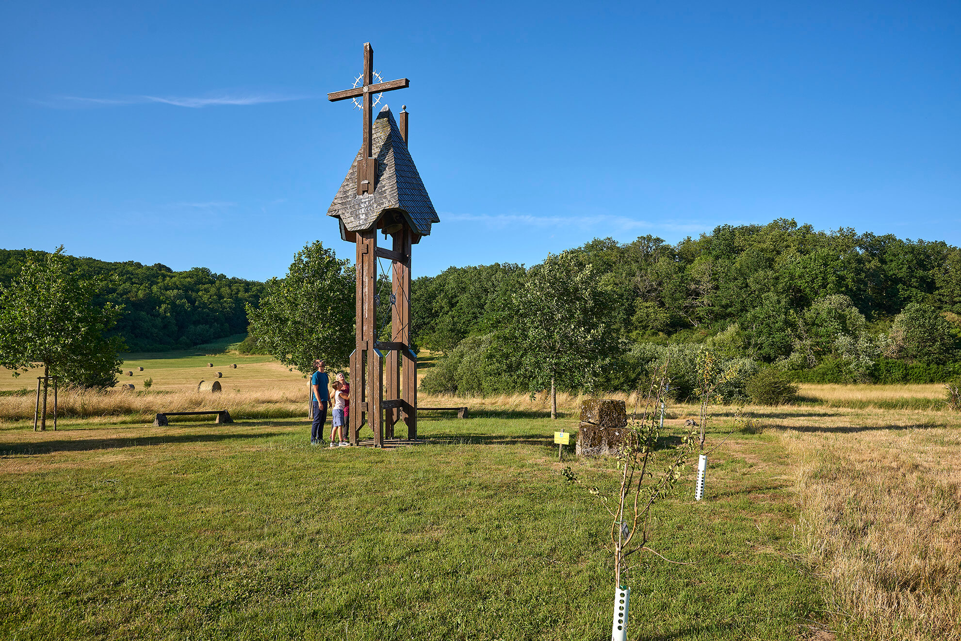 Hölzerner Glockenturm mit Kreuz in der Landschaft bei Strohn in der Vulkaneifel