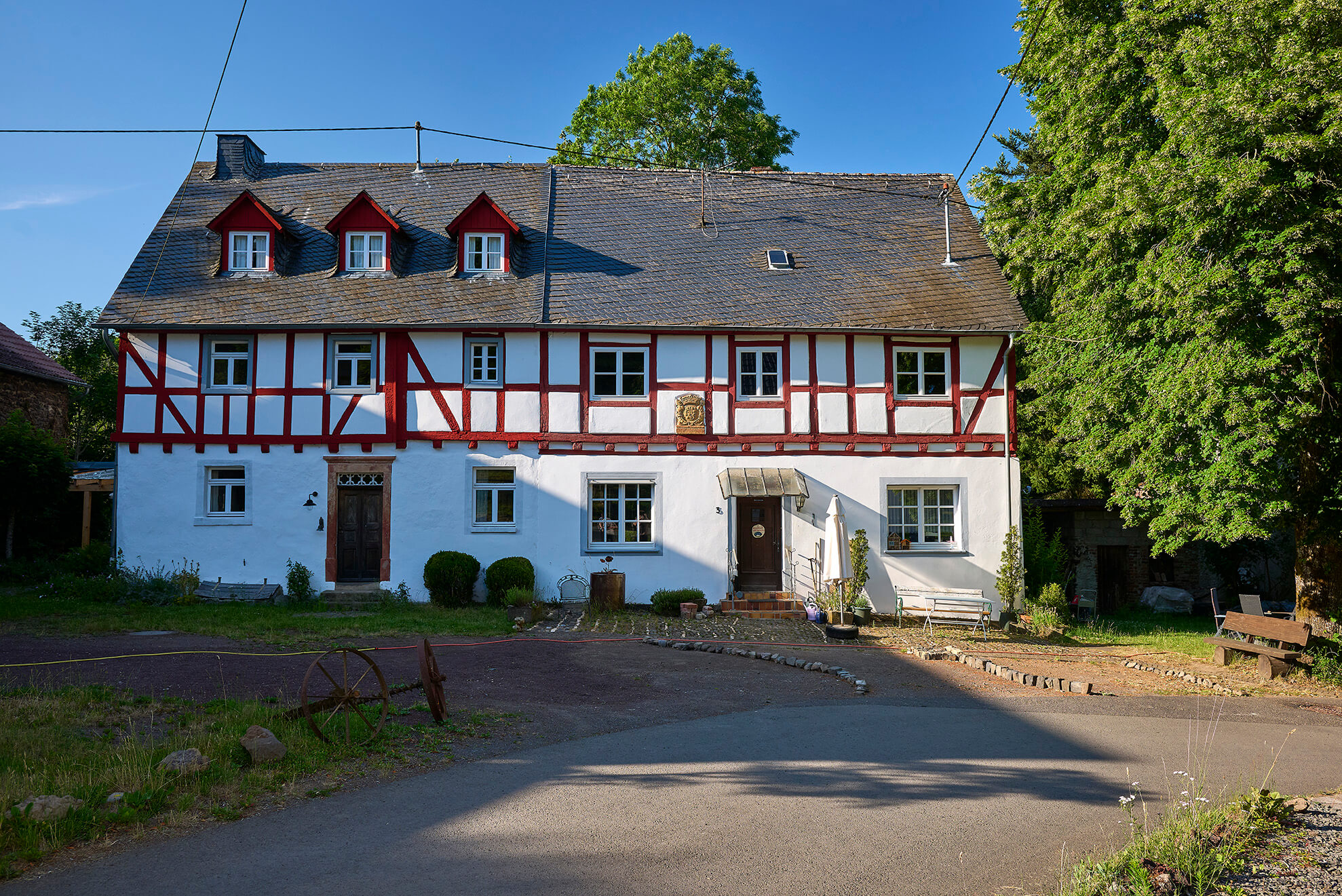 Historisches weißes Fachwerkhaus mit rot gestrichenem Holzfachwerk in Strohn in der Vulkaneifel