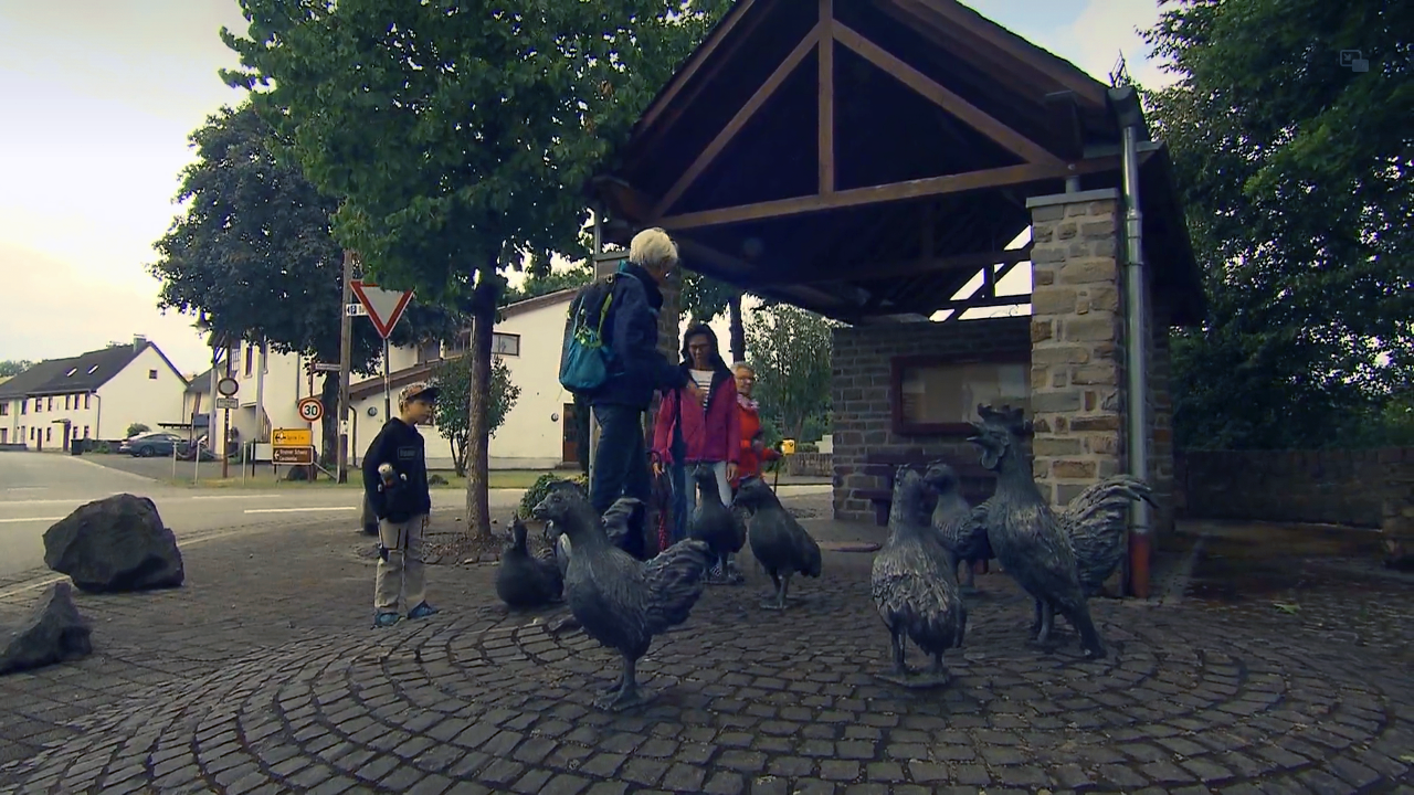 Besucher bei den Hühnerskulpturen in Strohn während eines Beitrags der Landesschau Rheinland Pfalz