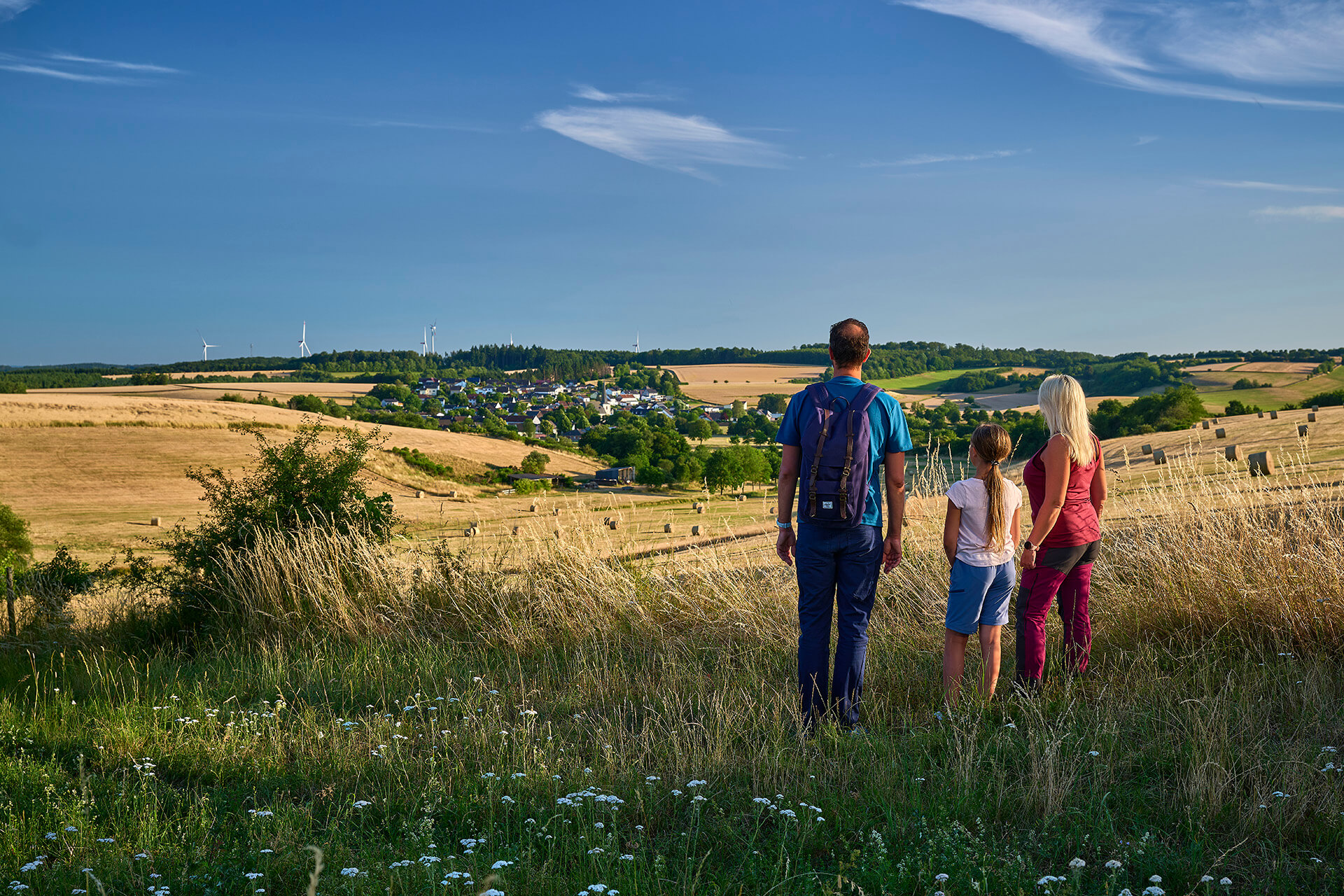 Wanderer mit Blick auf die Ortsgemeinde Strohn in der Vulkaneifel